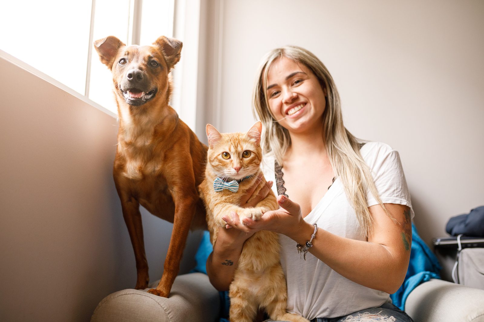 Tutora feliz com seu cachorro e gato